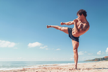 A muay thai or kickboxer training with shadow boxing outdoor at seashore