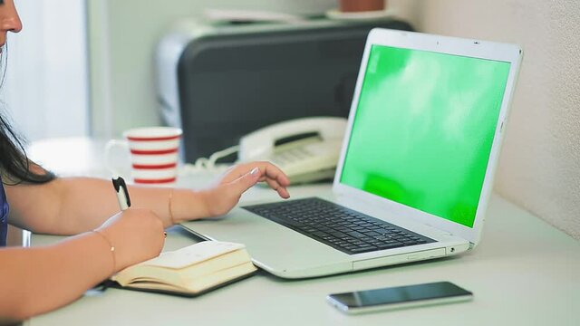 woman taking pictures without face type on laptop keyboard in home office