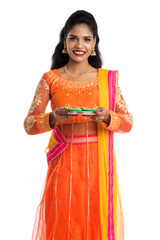 Portrait of a Indian Traditional Girl holding Diya, Girl Celebrating Diwali or Deepavali with...
