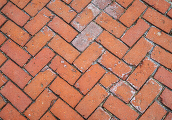 Background texture of decorative red brick terra cotta pavers in a herringbone pattern, design element.