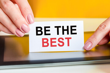 woman holds a piece of paper with the text be the best, concept