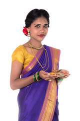 Indian woman performing worship, portrait of a beautiful young lady with pooja thali isolated on...
