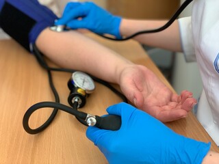 The doctor measures the patient's blood pressure using a tonometer. Medicine.