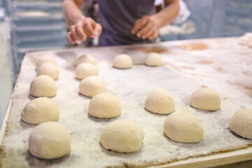 Fototapeta na wymiar Baker makes bread and buns for baking it