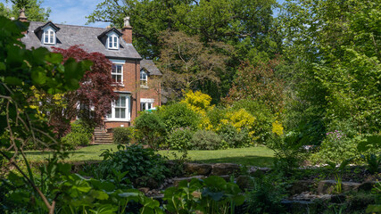Fototapeta na wymiar House made of red bricks looking across a garden