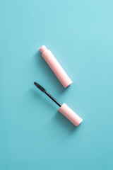 Mascara on blue background top view.