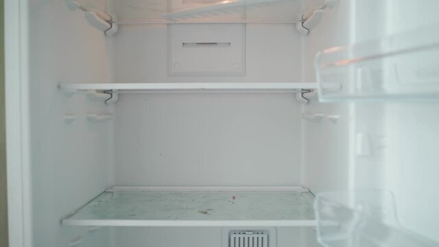 Unrecognizable Person Opens the Empty Refrigerator. Poverty and Economic Crisis Concept. No Money or Food. Shooting from the First Person. POV 