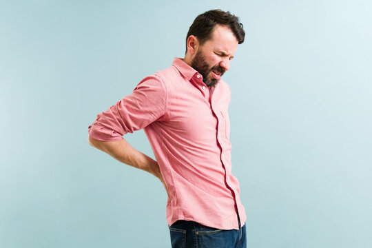 Latin Man Rubbing His Back From Stress