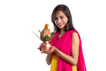 Indian girl holding a traditional copper Kalash, Indian Festival, copper Kalash with coconut and...