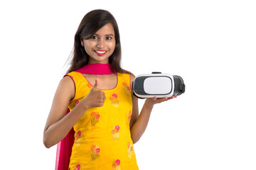 Indian traditional young girl holding and showing VR device, vr box, goggles, 3D Virtual Reality Glasses headset, Girl with Modern imaging Future technology on white background.