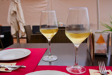 Glasses with white wine on a table for two in a restaurant