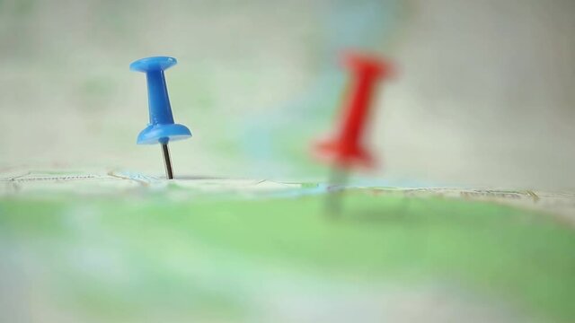 Man use pinned travel map and color pins at some location where he want to be 