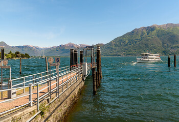 Naklejka premium Ferry boat at the pier on the shore of lake Maggiore in Locarno, Ticino, Switzerland