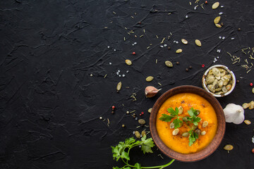 Delicious healthy pumpkin soup, herbs, and ingredients for the dish. Creative atmospheric decoration