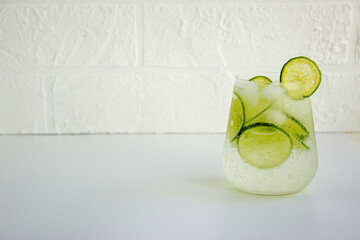 Refreshing lemonade with lime, mint, ice on a white background, place for text.