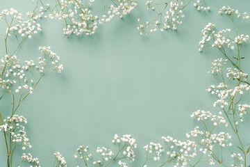 Flowers composition. White flowers on turquoise blue background. Wedding mockup with small flowers....