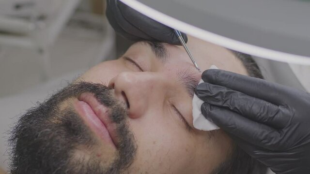 Close-up of a man's face at the reception of a beautician. A man with a beard.