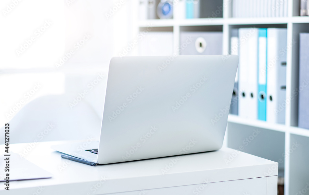 Wall mural modern laptop on white table in light office