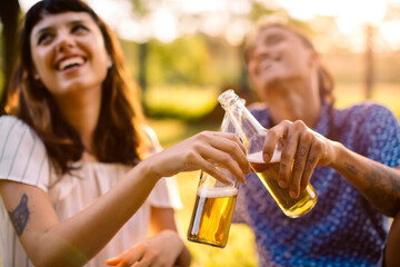 Laughing couple toasting beer bottles