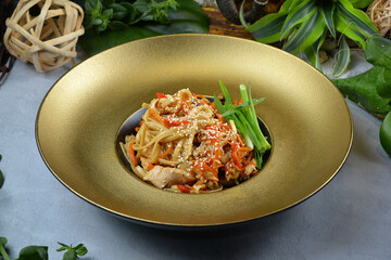 delicious spaghetti pasta with chicken viewed from the side on golden plate - Image thai food