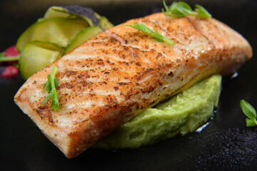fish steak served on black plate for restaurant menu closeup - Image