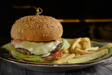 fresh tasty burger and french fries on wooden table
