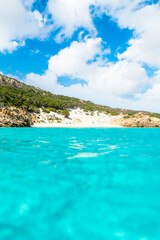 (Selective focus) Stunning view of a white sand beach bathed by a beautiful turquoise sea during a sunny day. Isola di Spargi, Maddalena Archipelago, Sardinia, Italy.