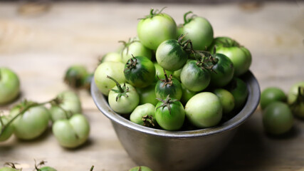 Green tomatoes in a bowl. Harvesting green tomatoes.