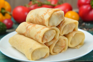 Crepes, thin pancakes with different sauces,on wooden table