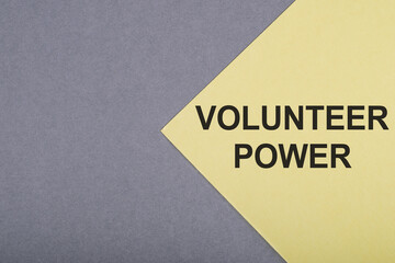 Text VOLUNTEER POWER on a yellow paper on gray background