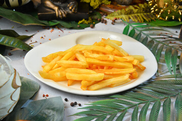 Crisp golden deep fried french fries; hot potatoes on white plate with decorated background - Image
