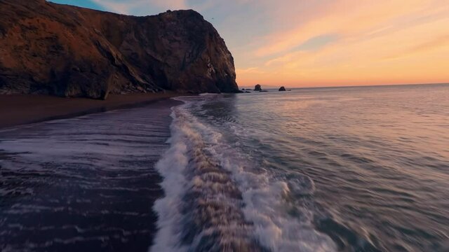 Aerial flying over the ocean water and cliffs at sunset. Tenessee Valley, San Francisco
