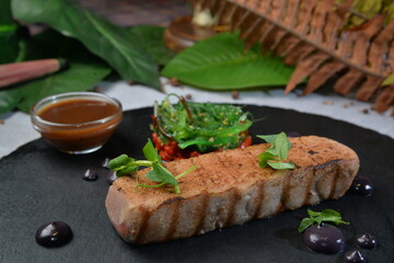 Grilled Tuna Fish Fillet with chuka salad served on black round plate - Image