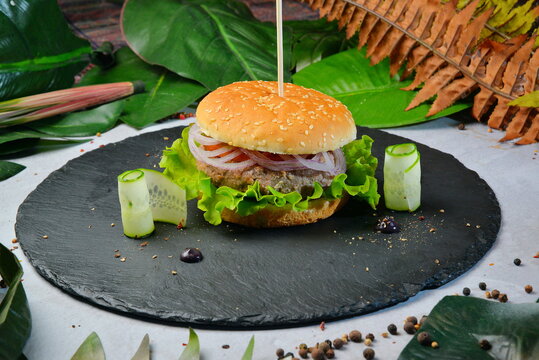 Delicious grilled burger on dark plate background - Image