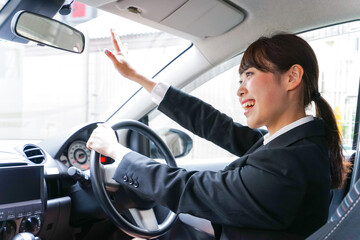 車で外回り営業をする女性