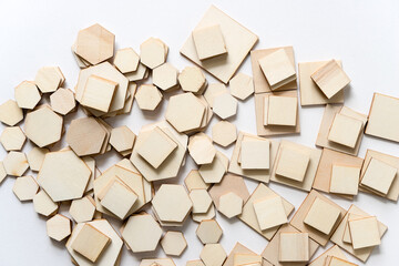 hexagonal and square shapes in wood arranged loosely on a white background