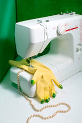 Maquina de coser cosiendo guantes amarillos manchados con radiación y perlas