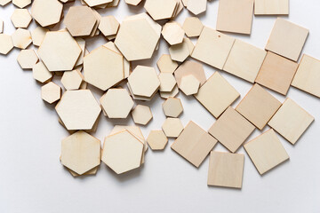 hexagonal and square shapes in wood arranged loosely on a white background