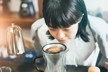 コーヒー豆の香りに笑顔を見せる若い女性