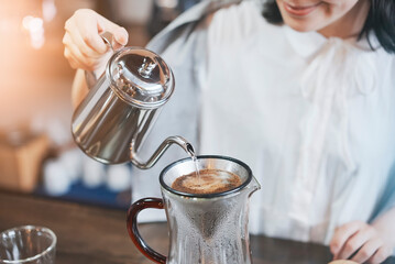 おしゃれな空間で、コーヒーを淹れる若い女性