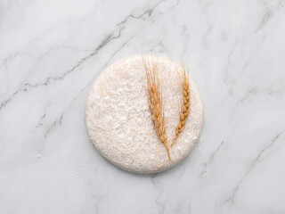 Fresh homemade yeast dough resting on marble table flat lay.