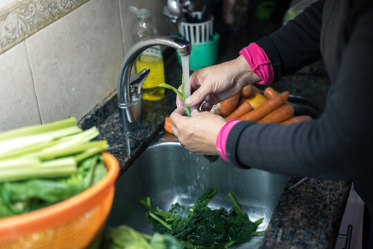 Mujer Blanca Lavando Hojas , Zanahoria Y Otros Vegetales Desde Casa Por La Cuarentena, Con Agua Limpiando Algunas Fruta Y Verdura Para Eliminar Las Posibilidades De Contaminación COVID-19,