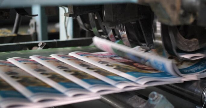 Polish tabloid headlines print copies from a printing press roller
