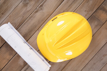 Yellow hard hat and a roll of drawings