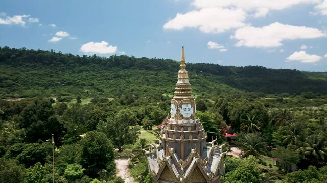 Eight sided buddhist shrine, drone orbit full 360 and zoom into buddha faces. Located in lush green foot hills of Phnom Kulen national park, Cambodia.