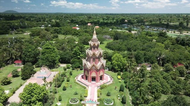 Beautiful eight sided buddhist shrine with birds flying around. Drone orbit in the lush green foot hills of Phnom Kulen national park, Cambodia.