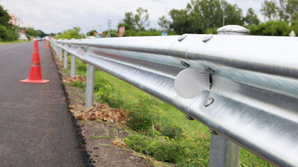 Reflective signs on the roadside railings. Silver steel railing on the road side with a red traffic...