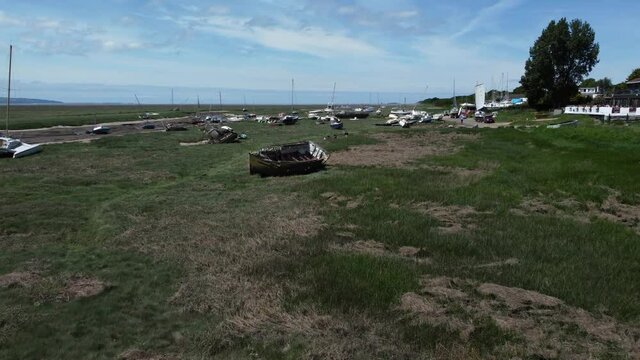 Abandoned old fishing boat carcass shipwreck in shipyard low tide mud flats graveyard push in
