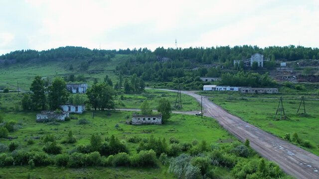 old abandoned buildings and buildings of the former mine. a beautiful place in nature near the hills and coniferous forest. aerial drone panoramic video