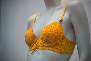 Closeup of orange color bra on mannequin in a fashion store showroom